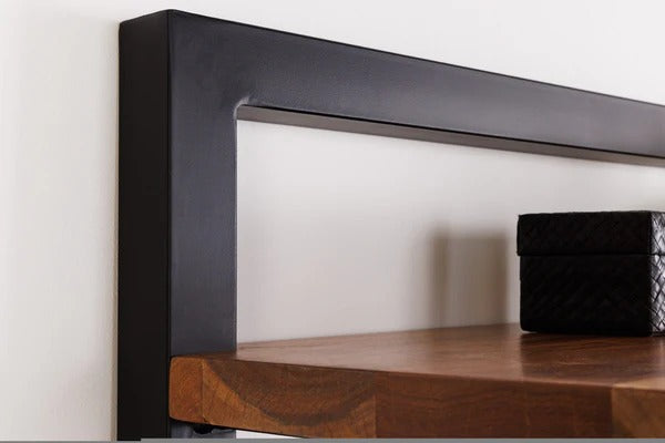 Wooden shelf with black metal bracket against a white wall