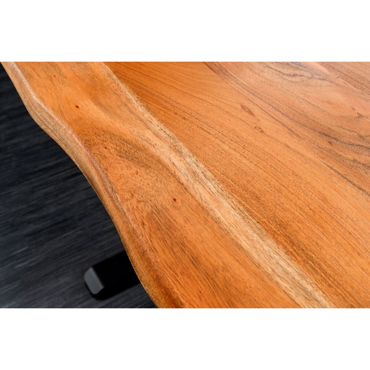 Close-up of a wooden surface with a black object partially visible