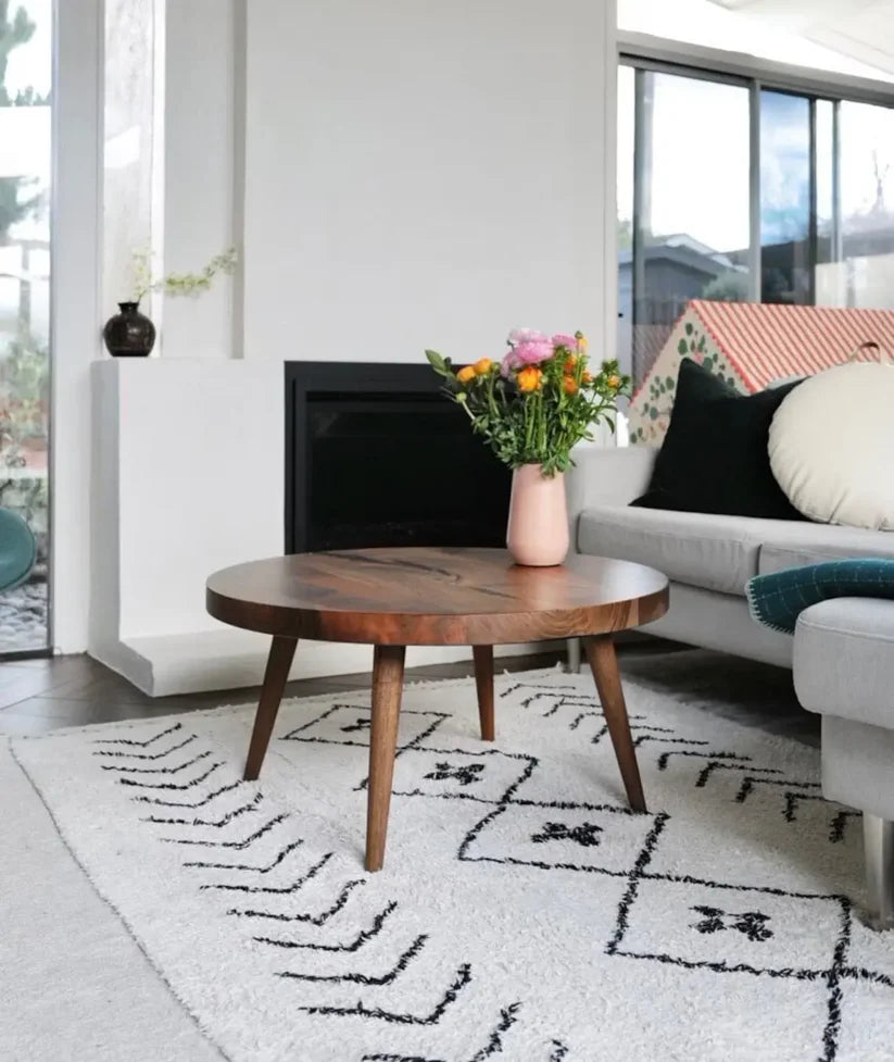 Living room with a wooden coffee table, gray sofa, and decorative rug.